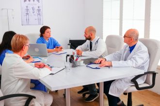 Team of expert doctors sitting at desk in hospital conference room having a briefing. Clinic expert therapist talking with colleagues about disease for treatment development, medicine professional SSUCv3H4sIAAAAAAAACpRVy47cNhC8B8g/LHQOEb6aj3xBLj7lGORAkdSMYI04kDROAmP/Pa03pZVtBLtYrLqLzepqsvj155/e3orS9bUvfnv7On7hd900r37o3FCnFsP0lyXexTbELo986YSieSCGekhd7Zo8WLrB31v3iBhsX00zht+nZNEPbnj1sc92f9S+S/2Q/Ocn0sAEW+v099cwxG7KYZzrNfFMbYBjpP5ncIfIA2s+72lIh5KPNDYZm/iI7TBmxJoJXXSPfqgn1nsZF1IZPzJgXHTVIVLWt7mJcc+8sHftIbEvCfGZ+npnyXWmlHdDvKG0B63Wyf05f7+tiWWjAVPF79E1w927Lv76CcfjcTbLhrOor3JEfap7H5vGtTGh6Gt+3vsbhf/wdWx9/B/V5n/+2rS84fp/x3bes0Y7nIabj8TSVsEUU5KCIF46S6SqFLHKV8RET10UwnIQK40CKlkqJgPxUAGRUBriDP6JLlChvLUe5AZWQYJm1hDunSCSckqM1YE4oRkPJXcsVBvYUGW55p5w8BFplCVxIVLiy5KxwKGKVm1gLp1wkSpSGUDO1jjkTKfyNDLrrXduAzNdKRlMJCxE5EwFVjYKG/SUWRkNOBU2cNDBg0A1KqAeacRIjKsYocaUlnoZpIAN7AR4AF0Rqu0oXZDEOukJraJk3FoBQW9gEWnwnAOJQlMiJbOk5AgGToXBxl1UdprmPMLi8994HR/TgVyG516hTtkB/ZLwvE33Kpvws6t93d6yZWm4T8ayLvPp1Q7deDSKjVyT0tOVzXgdK6wZ1/jd9T3CwxrP7wzaWHpk+7RpmA7WUrUIeKnGTyY4KKut0sABqBa0yP3pXmOdic5K8PVsEs5+3HS7GRfOpRjTghtutjtyNrEZApRlkNXOLnOLsV3ljhY3A4RZbfjK7RYQ0Ax0ML4FoPjqmGcLvAKsZniVO9viFebskCPGUo1TyVievHLGGAnTQduda3SkR42KH0f1oQdcS+33VDgD8kF8yGUDPOcu5o8QztS1fpgTQvywb2XlD8Z8Bl2LbAyT3x8WYqyQi8iHlxyBdchfp4PIhaRGCxyi3Y0s17jgI0FuYc+vEhfo0JZzsxvVKnDBpBZMS7s7+knfAgkLBiDUDln1RQLulnqPxZAJZxR/8Hfnd9K6kBKoUgB8g3yQenyrgAn0yW+994WxXMrco88yo1SAHVM5m+0icD2e4ALwqcFDHkilND5YVeSkpBU+AxV4y4MSlQy46v0/AAAA//8DACNrIWLaCQAA